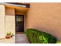 Close up of the front entry door with decorative wreath and adjacent landscaping at 10863 N 117Th Pl, Scottsdale, AZ 85259