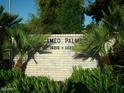 The address for Cameo Palm is displayed on a brick sign surrounded by lush green plants at 11141 W Cameo Dr, Sun City, AZ 85351
