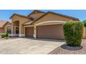 The attached garage has brown doors and is surrounded by desert landscaping at 11303 E Pratt Ave, Mesa, AZ 85212