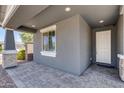 Inviting covered front porch featuring gray brick, neutral colors, and a well-lit entryway at 13171 W Redstone Dr, Peoria, AZ 85383