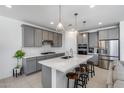 Well-lit kitchen features gray cabinets, stainless steel appliances, a large island, and bar stool seating at 13171 W Redstone Dr, Peoria, AZ 85383