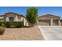 Charming home featuring a desert landscape, a three-car garage and a lush tree providing shade at 1804 W Magdalena Ln, Phoenix, AZ 85041