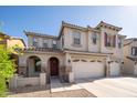 Charming two-story home with a three-car garage, arched entryway and well-manicured front yard at 18401 W Westfall Way, Surprise, AZ 85374