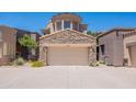 Home exterior with a stone accent garage and desert landscaping on a sunny day at 19475 N Grayhawk Dr # 1039, Scottsdale, AZ 85255