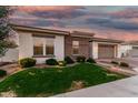 Charming home featuring manicured lawn, beautiful brick accents, and a lovely paver driveway leading to a two-car garage at 2052 E Scorpio Pl, Chandler, AZ 85249