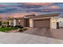Charming home featuring manicured lawn, beautiful brick accents, and a lovely paver driveway leading to a two-car garage at 2052 E Scorpio Pl, Chandler, AZ 85249