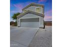 Two-story home with a large driveway and a two-car garage, taken during a colorful sunset at 21754 W Pima St, Buckeye, AZ 85326
