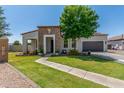 Inviting single-Gathering home with stone accents, lush green lawn, and a well-maintained landscape at 24350 S 208Th Pl, Queen Creek, AZ 85142