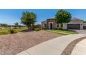 Beautiful single-story residence with stone detail, easy care xeriscape, and a green lawn at 24350 S 208Th Pl, Queen Creek, AZ 85142