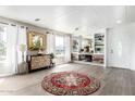 Bright living room featuring wood-look floors, a round rug, and a decorative mirror at 2650 W Union Hills Dr # 98, Phoenix, AZ 85027