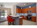 Modern kitchen features stainless steel appliances, wood cabinets, white countertops, and a stylish breakfast bar with red bar stools at 26633 N 41St Way, Cave Creek, AZ 85331