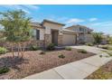 Single-story home with desert landscaping, stone accents, and a two-car garage at 28065 N 171St Dr, Surprise, AZ 85387