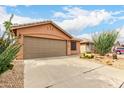 Single-story home with xeriscaping, a two-car garage, and a concrete driveway at 3353 E Blackhawk Dr, Phoenix, AZ 85050