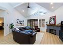 Spacious living room with vaulted ceilings, clerestory windows, fireplace, and comfortable leather furniture at 4039 E Paradise Dr, Phoenix, AZ 85028