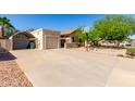 Exterior view of home and driveway featuring basketball hoop, garage, covered parking and desert landscaping at 4102 W Bluefield Ave, Glendale, AZ 85308