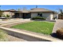 View of the home with manicured green lawn and desert landscaping at 4213 N Westview Dr, Phoenix, AZ 85015