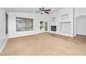 Spacious living room featuring a ceiling fan, fireplace, and neutral paint at 4455 E Marshall Ave, Gilbert, AZ 85297