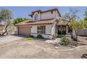 Charming two-story home with a tile roof and mature trees surrounding the property at 4627 E Mcneil St, Phoenix, AZ 85044