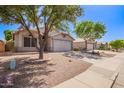 Street view showcasing a single-story home with desert landscaping, two-car garage, and a paved walkway at 4911 E Holmes Ave, Mesa, AZ 85206