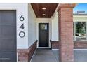 Welcoming front entry showcases a brick pillar, a stylish wooden ceiling, and a modern black front door at 640 S 34Th St, Mesa, AZ 85204