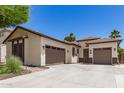 Home with a desert themed yard leading to a two car garage and an additional single car garage at 6805 S Sapphire Way, Chandler, AZ 85249