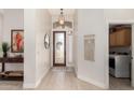 Bright foyer featuring tiled floors, decorative lighting, and access to the laundry room at 6958 W Morning Dove Dr, Glendale, AZ 85308