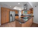 Bright kitchen featuring stainless steel appliances, a modern range hood, and a skylight providing natural light at 9051 E Grandview Dr, Mesa, AZ 85207