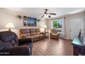 Cozy living room featuring hardwood floors, comfortable seating, and a large window with natural light at 9051 E Grandview Dr, Mesa, AZ 85207
