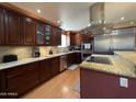 Modern kitchen with stainless steel appliances, granite countertops, and wood cabinets at 9221 N 48Th Dr, Glendale, AZ 85302