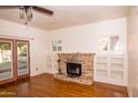 Cozy living room with hardwood floors, fireplace, built-in bookshelves, and French doors at 937 E 6Th Ave, Mesa, AZ 85204