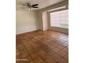 Neutral living room with tile flooring, ceiling fan, and natural light from a window at 1022 E Keim Dr, Phoenix, AZ 85014