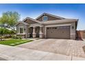 Attractive exterior of a single-Gathering home featuring a brick driveway and manicured landscaping at 1026 N 152Nd Ave, Goodyear, AZ 85338