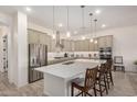 Gourmet kitchen featuring a large island, stainless steel appliances, and pendant lighting at 1026 N 152Nd Ave, Goodyear, AZ 85338