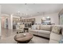 Bright, open living room with modern decor flowing seamlessly into a stylish kitchen and dining area at 1026 N 152Nd Ave, Goodyear, AZ 85338