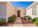Inviting front entryway with desert landscaping and cozy bench at 12910 W Junipero Dr, Sun City West, AZ 85375