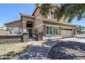A lush front yard, stone retaining wall, brick walkway, and gated entrance greet you at this two-story home at 1311 N Congress Dr, Chandler, AZ 85226