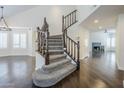 Dramatic staircase with wood banister, leading to large living room with fireplace at 1311 N Congress Dr, Chandler, AZ 85226