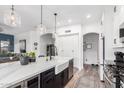 Bright, airy kitchen with a large center island, stainless steel appliances, pendant lights and white cabinets at 1312 W Bartlett Way, Chandler, AZ 85248