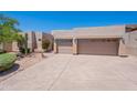 Tan home showcasing a large driveway and attached garages with desert landscaping and blue skies overhead at 14806 E Lookout Ledge --, Fountain Hills, AZ 85268