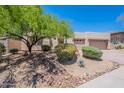 Tan house featuring a large front yard with desert landscaping, rock detail and a charming desert tree for shade at 14806 E Lookout Ledge --, Fountain Hills, AZ 85268