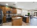 Beautiful kitchen featuring stainless appliances, granite counters, mosaic backsplash, and island with breakfast bar at 17541 W Statler Dr, Surprise, AZ 85388