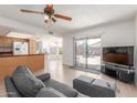 Open-concept living room featuring tile flooring, a ceiling fan, and sliding glass doors to the backyard at 2031 W Gila Ln, Chandler, AZ 85224