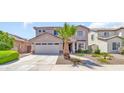 Attractive two-story home with a well-manicured lawn, mature landscaping, and a spacious two car garage at 21167 E Aspen Valley Dr, Queen Creek, AZ 85142