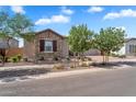 Attractive single-story home showcasing stone accents, desert landscaping and a well-maintained lawn at 21934 E Lords Ct, Queen Creek, AZ 85142