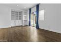 Open living space with custom built-ins, hardwood floors, and sliding glass doors at 21973 N 102Nd Ln # 411, Peoria, AZ 85383