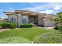 Charming home with arched windows, a cozy porch, and a well-maintained lawn with beautiful shrubs at 2243 E Cortez Dr, Gilbert, AZ 85234