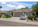Charming single-story home featuring a tile roof, three-car garage, and manicured front yard at 2243 E Cortez Dr, Gilbert, AZ 85234