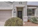 Close-up of the home's entrance, featuring a dark front door and desert landscaping at 30996 W Osborn Rd, Buckeye, AZ 85396