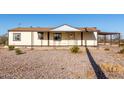 Charming one-story home boasts a covered front porch, attached porte-cochere, and low-maintenance gravel landscaping at 3349 N Ralston Rd, Maricopa, AZ 85139