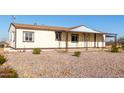A charming, one-story home featuring a covered front porch and attached porte-cochere, surrounded by gravel landscaping at 3349 N Ralston Rd, Maricopa, AZ 85139